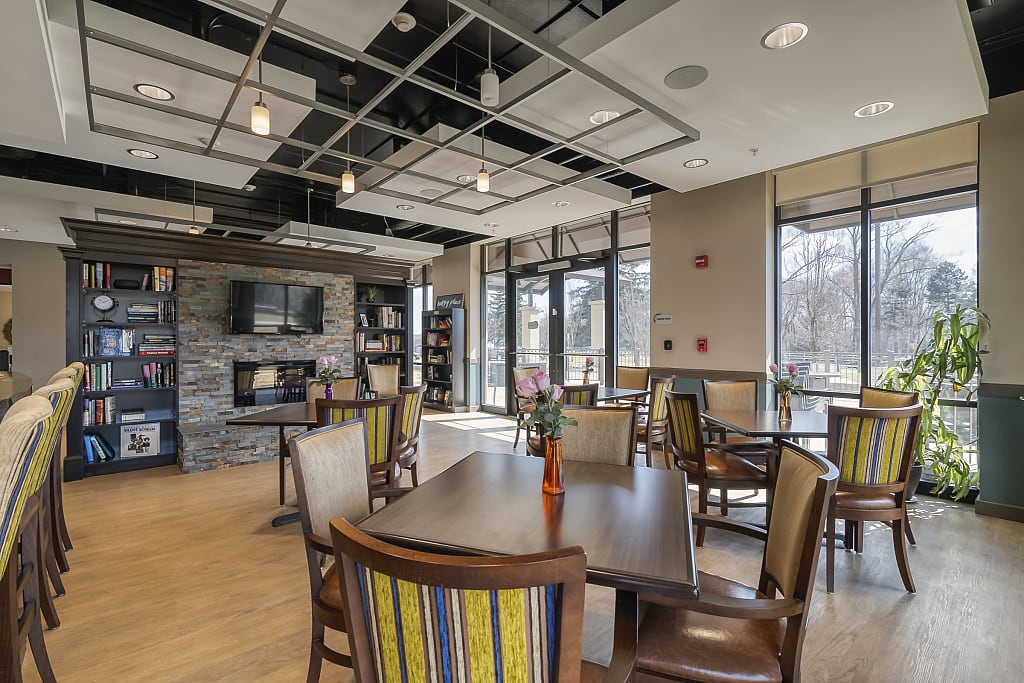 Spacious-common-area-seating Common area with tables and chairs, fireplace, and tv.