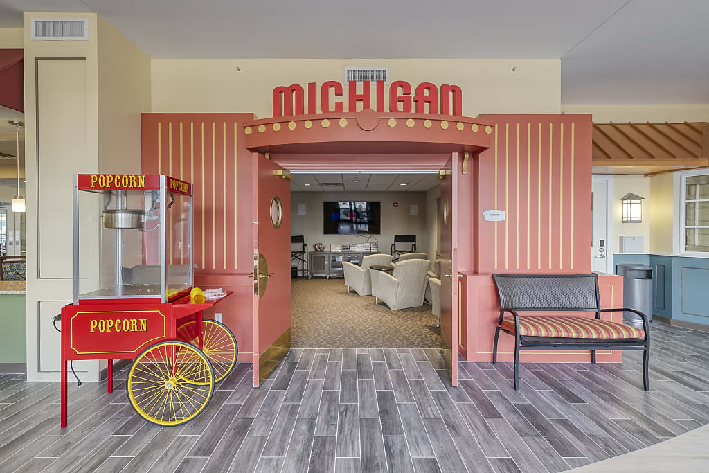 community-movie-theatre-entrance Community movie theatre entrance with popcorn machine, a Michigan sign, and comfortable seating.