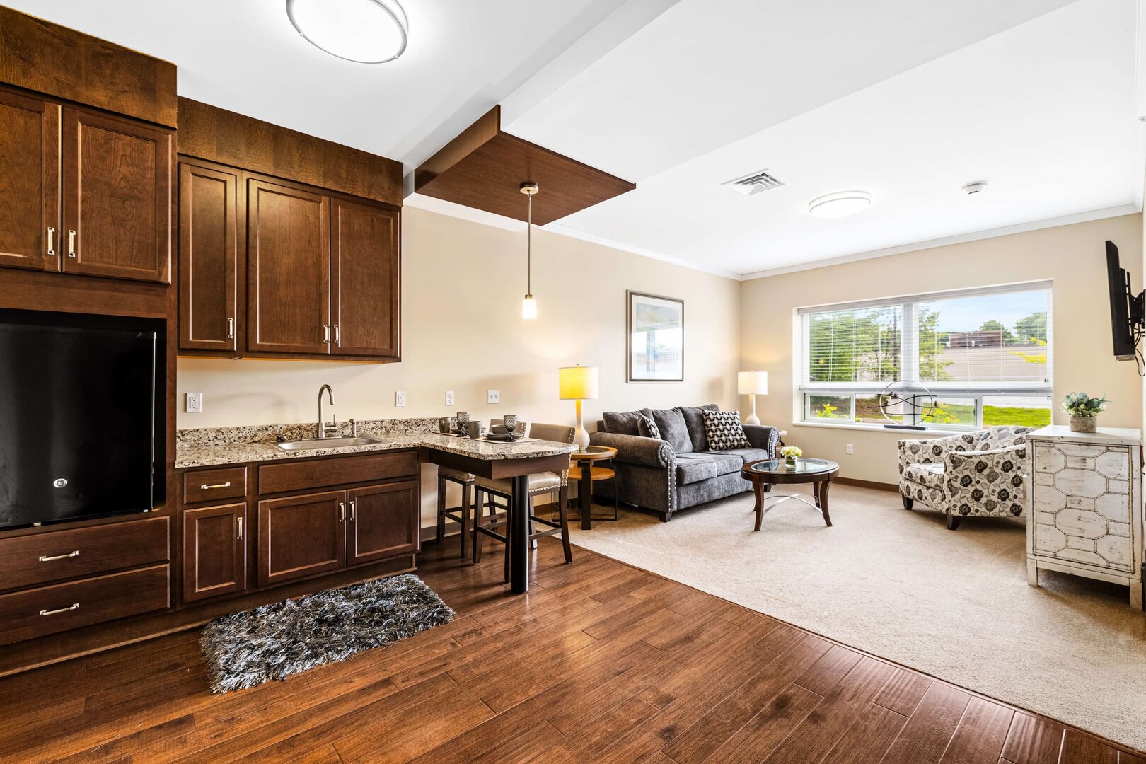 avalon-modern-living-unit Spacious living area with kitchenette, seating, and large window in a modern unit.