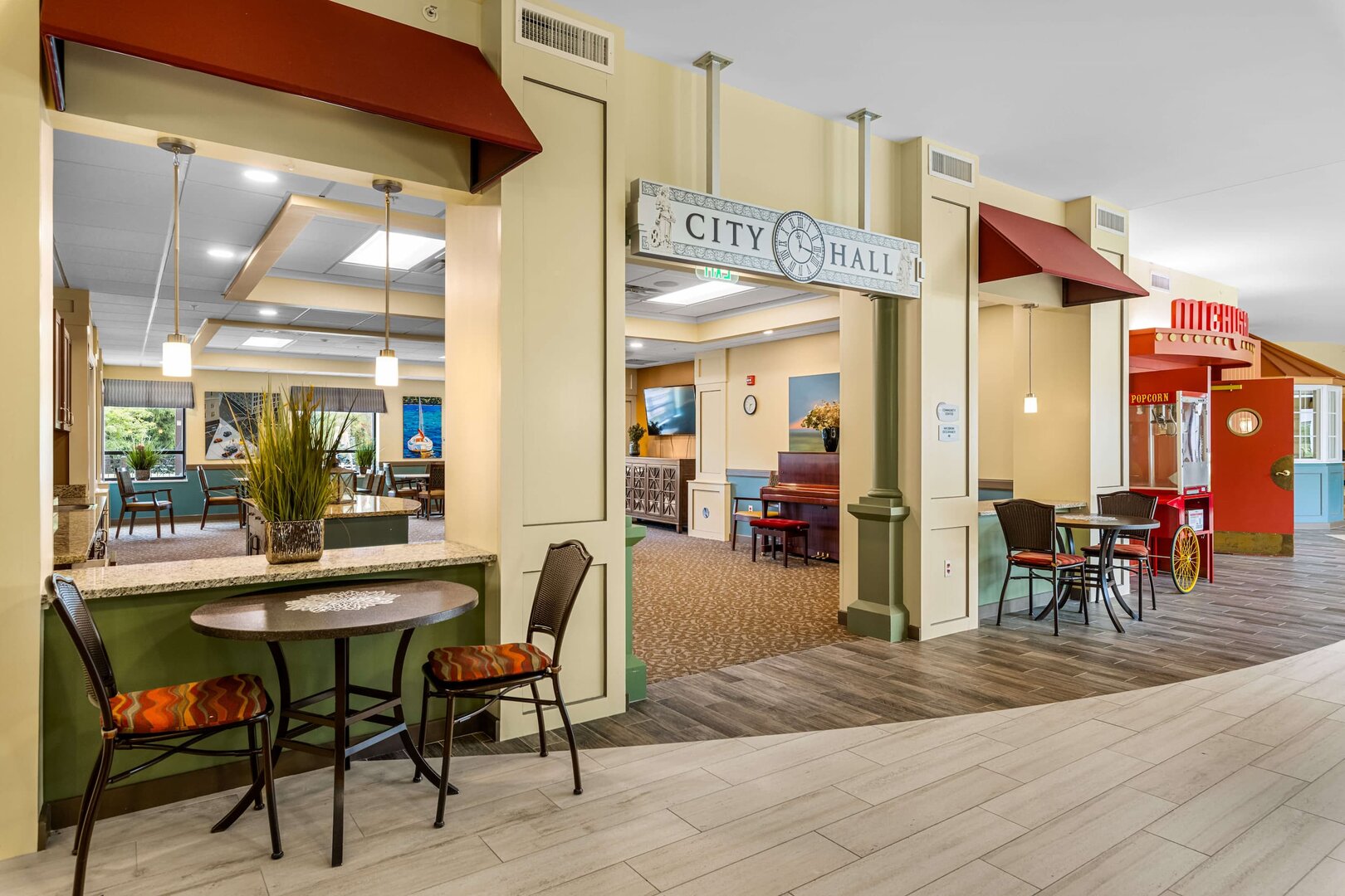 common-area-senior-living-community Interior of a senior living community with tables, chairs, and a piano in a common area.