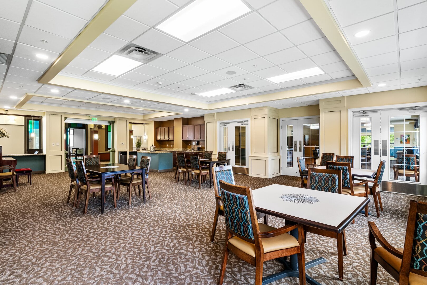 dining-area-community-center-b-20 Spacious dining area with multiple tables and chairs in a community center.