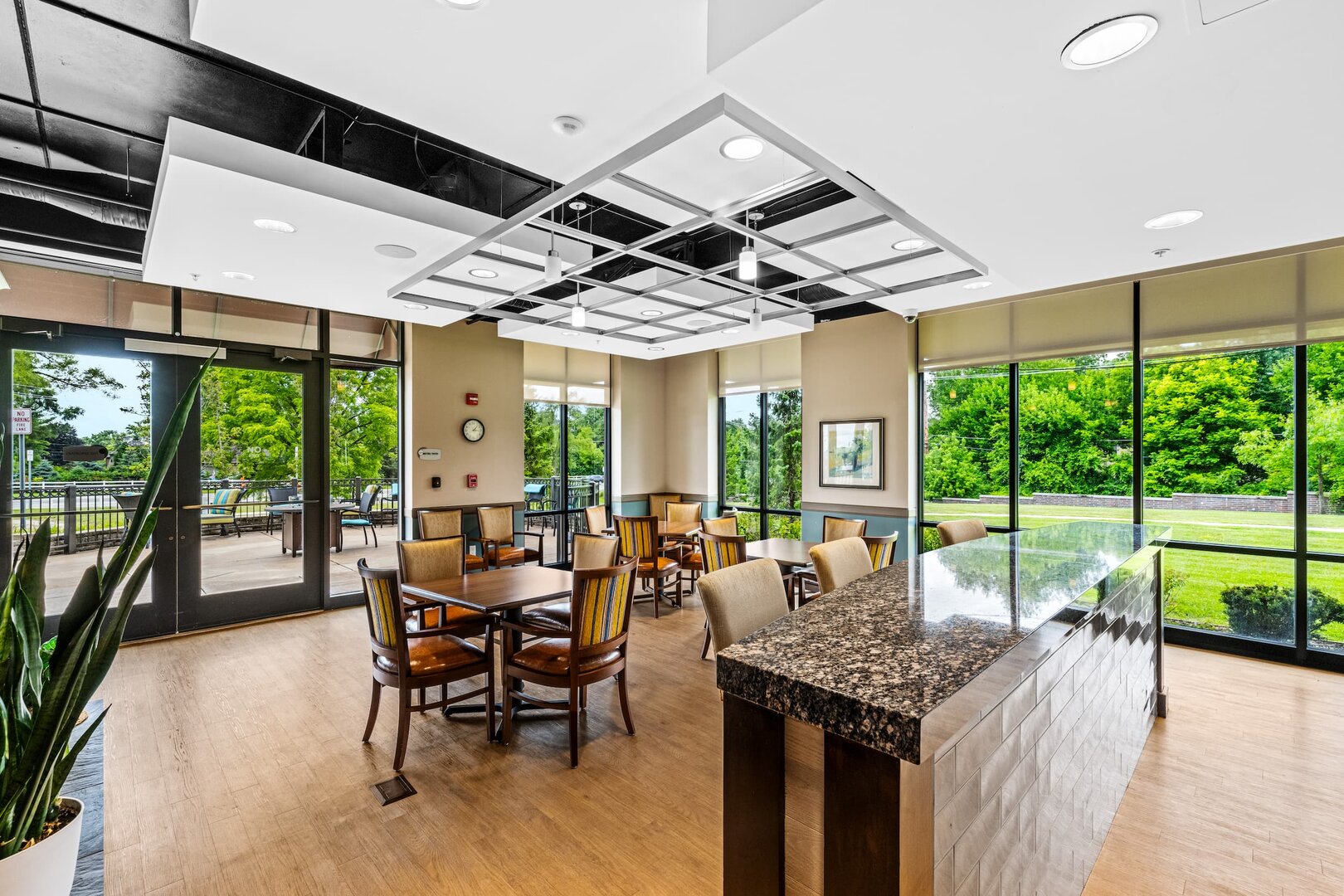dining-area-glass-windows-scenic-view Bright and spacious dining area with large windows overlooking greenery.