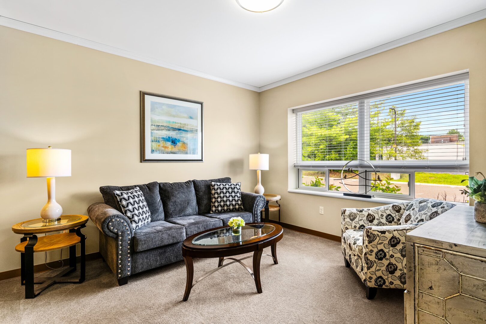 inviting-living-room-modern-decor Cozy unit living room with sofa, armchair, table, and large sunny window.