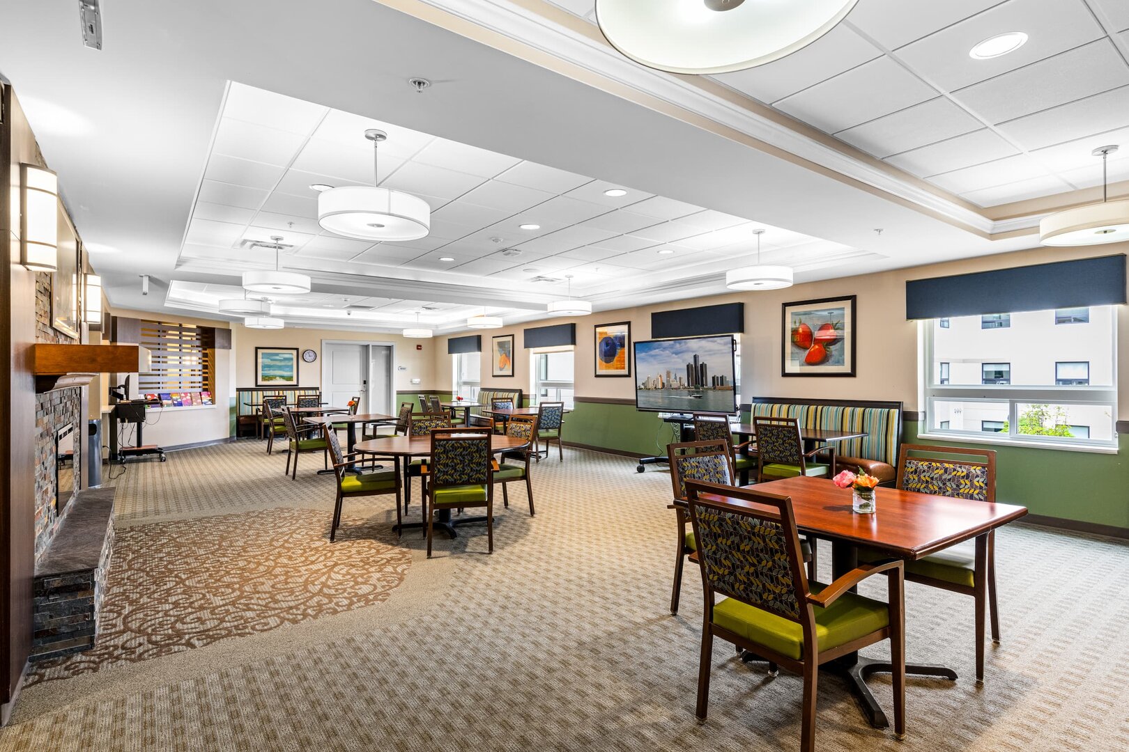 recreation-room-senior-facility Spacious recreation room with tables, chairs, and modern decor in a senior living community.