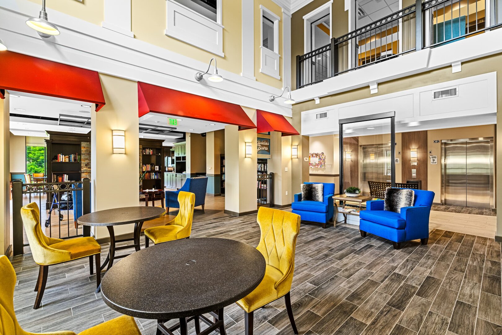 senior-community-lounge-modern-setting-b-03 Bright senior community lounge with blue chairs, yellow seating, and modern decor.