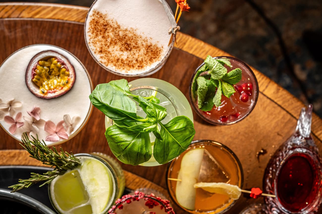 various craft cocktails on a wooden tray